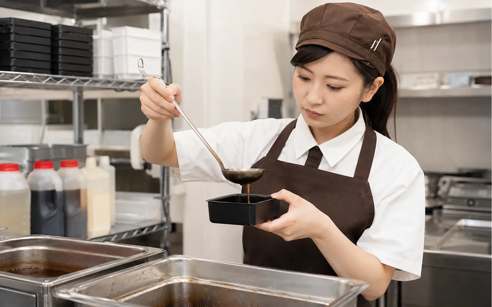 計量器具を使って盛り付けを確認するほっともっとクルーのイメージ